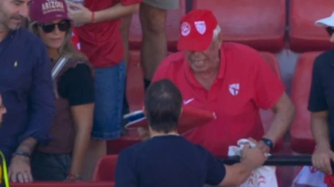 Almeyda escucha al veterano hincha de Sevilla molesta por la derrota de su equipo. foto: @laliga.