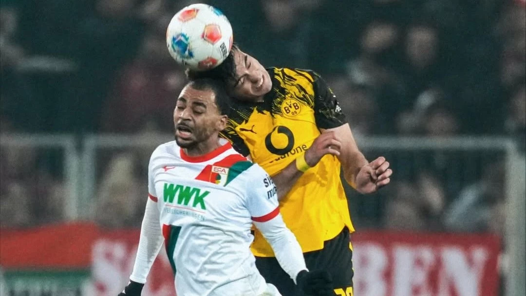 Anselmino despeja ante la presión de un rival del Augsburgo. foto: @bvb09.